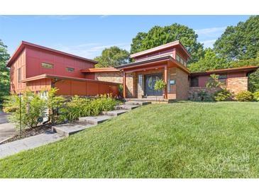 Inviting home with red wood and brick exterior, mature landscaping, and stepped pathway to the front door at 640 Davie Ave, Statesville, NC 28677