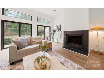 Bright living room features a fireplace, hardwood floors, and sliding glass doors leading to a patio at 35 Old Post Rd, Clover, SC 29710