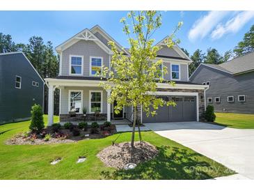 Beautiful two-story home featuring stone accents, a two-car garage, and professionally landscaped front yard at 2024 Cedar Falls Dr # 9, Waxhaw, NC 28173