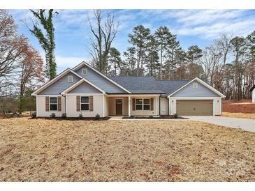 Charming one-story home featuring a mix of board and batten siding, shutters, and a spacious two-car garage at 6201 Long Branch Rd, Salisbury, NC 28147