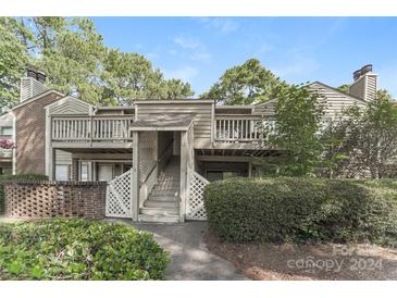 Charming two-story townhouse featuring well-maintained landscaping, and a private entrance with stairs and a deck at 1600 Sharon W Rd # 11, Charlotte, NC 28210