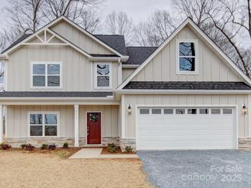 Two-story house with a gray exterior, white garage door, and landscaping at 2613 Plyler Mill Rd, Monroe, NC 28112