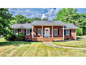 Brick ranch house with covered porch, landscaped yard, and walkway at 2909 Eastway Dr, Statesville, NC 28625