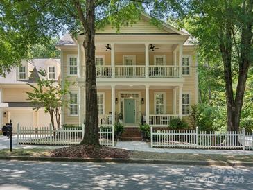 Charming two-story home with a double porch, a white picket fence, and a well-manicured front yard at 927 Dericks Xing, Fort Mill, SC 29708