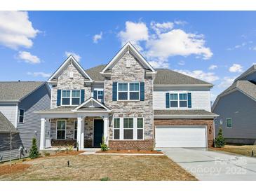 Beautiful two-story home showcasing stone facade, blue shutters, and a well-manicured lawn under a bright sky at 121 Clawton Loop, Mooresville, NC 28115