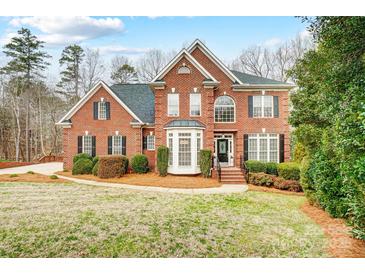 Brick house with a large front yard, landscaping, and a walkway at 2804 Providence View Ln, Charlotte, NC 28270