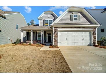 Two-story home with gray siding, stone accents, and a two-car garage at 5308 Verona Rd # 75, Charlotte, NC 28213