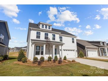 Charming two-story home with white siding, a welcoming front porch, and an attached two-car garage at 633 Amberjack Pl, York, SC 29745