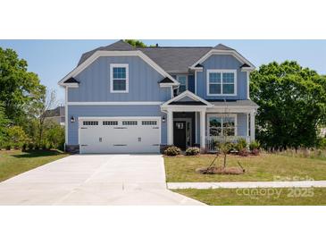 Charming two-story home features a light blue exterior, a two-car garage, and manicured front lawn at 4684 Hopsack Dr # Cal0105, Indian Trail, NC 28079