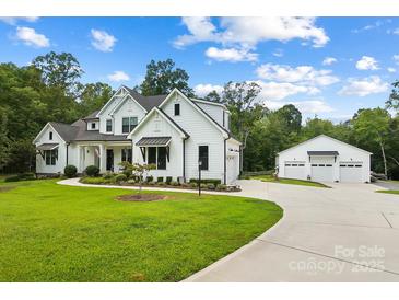 White farmhouse with attached three-car garage and spacious driveway at 5811 Kristi Ln, Midland, NC 28107