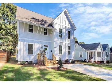 Charming two-story home featuring vertical siding, complemented by a well-manicured front yard and inviting entryway at 3230 Rogers St, Charlotte, NC 28208