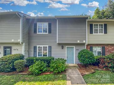 Charming townhome featuring a light blue front door, gray siding and well-maintained landscaping at 6003 Heath Valley Rd, Charlotte, NC 28210