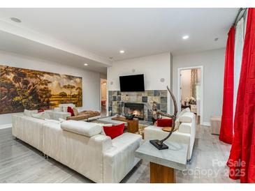 Bright living room features a cozy fireplace, tile accents, and comfortable seating at 3020 Poplar Hill Rd, Charlotte, NC 28270