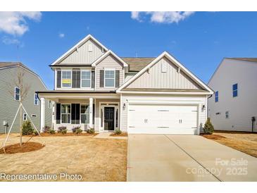 Two-story house with a white and gray exterior, two-car garage, and landscaped yard at 8611 Frank Grier Rd # 1, Charlotte, NC 28215