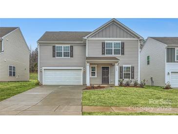 Two-story house with gray siding, a white garage door, and a landscaped lawn at 1608 Cannonball Ln, Bessemer City, NC 28016