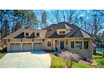 Charming stone home with a three-car garage, well manicured lawn and mature trees at 301 Agnew Rd, Mooresville, NC 28117