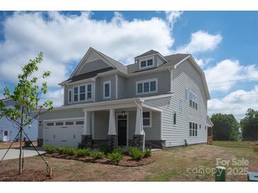 Charming two-story home showcasing meticulous landscaping, stone accents, and a covered front porch at 4808 Glen Stripe Dr # Cal0036, Indian Trail, NC 28079