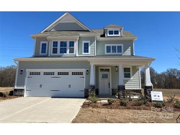 Charming two-story home with a two-car garage, stone accents, and inviting front porch at 4808 Glen Stripe Dr # Cal0036, Indian Trail, NC 28079