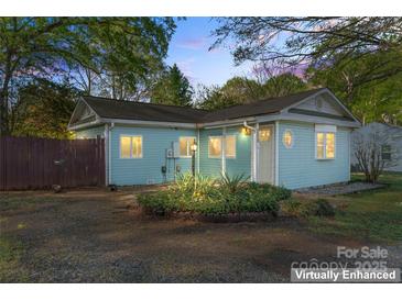 Charming single-story home featuring light blue siding, well-manicured landscaping, and welcoming front entrance at 209 21St St, Newton, NC 28658