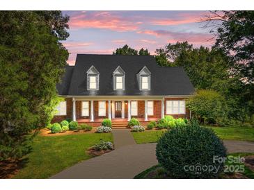 Brick house with a front porch, landscaping, and a large yard at dusk at 721 Orphanage Rd, Concord, NC 28027