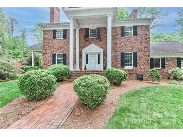 Charming two-story brick home with a columned front porch and manicured landscaping at 715 Saint Cloud Dr, Statesville, NC 28625