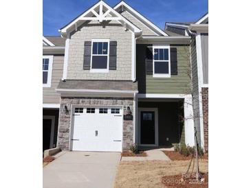 Two-story townhome with gray and green siding, white garage door, and landscaping at 4061 Lawnview Dr, Charlotte, NC 28269