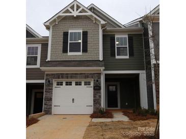 Two-story townhome with gray siding, stone accents, and a two-car garage at 4061 Lawnview Dr, Charlotte, NC 28269