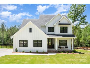 Stunning two-story modern farmhouse with white siding, black trim, and rocking chair front porch at 199 Heartland Dr # 10, Rock Hill, SC 29732