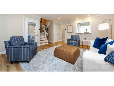 Comfortable living room featuring hardwood floors, neutral colors, and ample natural light at 430 Queens Rd # 712, Charlotte, NC 28207