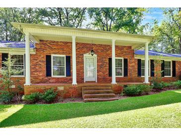 Brick ranch house with a covered porch and landscaped yard at 1801 Windsor Dr, Lancaster, SC 29720