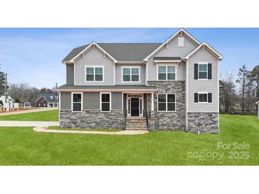 Stunning two-story home featuring a stone facade, gray siding, multiple windows, and a well-manicured lawn at 133 Jentri Way, Mooresville, NC 28115