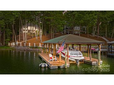 Covered boat dock with a boat and American flag at 167 Maple View Dr, Troutman, NC 28166