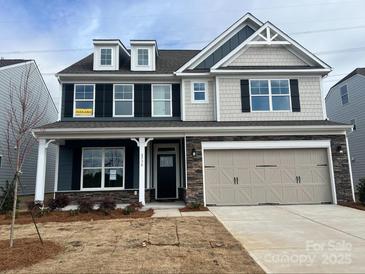 Two-story home with gray siding, stone accents, and a three-car garage at 8736 Acadia Pkwy # 601, Sherrills Ford, NC 28673