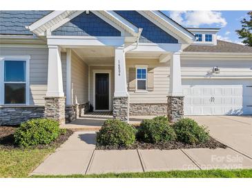 Charming home entrance with stone accents on columns and a well-maintained landscaped front yard at 16004 Deer River Rd, Charlotte, NC 28278