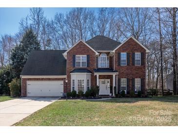 Charming two-story brick home with a well-manicured lawn and attached two-car garage at 1424 Moonstone Dr, Matthews, NC 28105