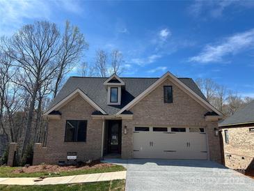 Charming brick home with a two-car garage and a well-manicured lawn on a sunny day at 5106 Silver Trace Ln # 90, Denver, NC 28037