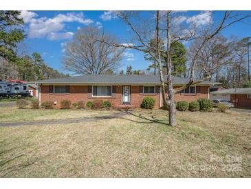 Charming brick ranch home with mature landscaping and a walkway to the front door at 1206 Mineral Springs Rd, Charlotte, NC 28262