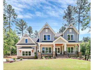 Charming two-story home with a landscaped yard, covered porch and gray siding at 6178 Chimney Bluff Rd, Lancaster, SC 29720