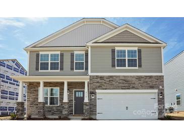 Two-story home features stone accents, gray siding, a two-car garage, and a welcoming front door at 210 Giant Oak Ave, Statesville, NC 28677