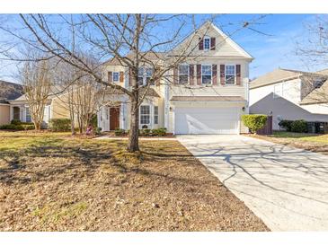 Two-story house with beige siding, brown shutters, and a large driveway at 9718 Waltham Ct, Charlotte, NC 28269