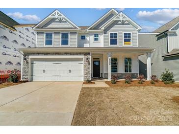 Charming two-story home with a stone facade, manicured lawn, and attached two-car garage at 2008 Embassy Ct # 45, Charlotte, NC 28213