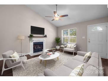 Living room with fireplace, hardwood floors, and lots of natural light at 2008 Duke Adam St, Kannapolis, NC 28083