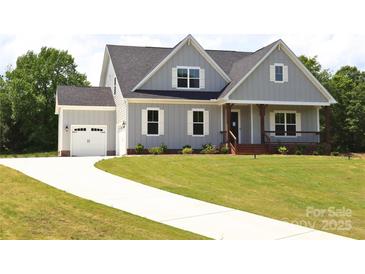 Charming gray home with a neatly manicured lawn and a concrete driveway leading to an attached garage at 1228 Sage Pine Cir # 12, Clover, SC 29710