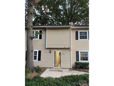 Tan two-story townhome with white shutters and a small front porch at 3178 Heathstead Pl, Charlotte, NC 28210