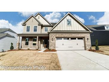 Brick two-story house with a three-car garage and landscaped lawn at 3221 Mcharney Dr # 31, Harrisburg, NC 28075