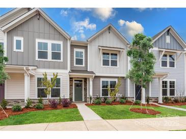 Three-unit townhome building, gray siding, green doors, landscaping at 10511 Boudreaux St, Huntersville, NC 28078