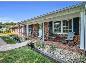 Classic brick home featuring a welcoming front porch, rocking chairs, and charming curb appeal at 3039 Longwood Dr, Shelby, NC 28152