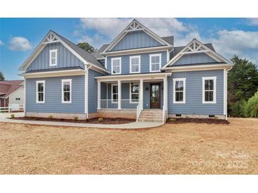 Charming two-story home with a welcoming front porch, light blue siding, and white trim at 332 Canvasback Rd, Mooresville, NC 28117