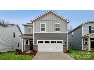 Two-story home with gray siding, white garage door, and landscaping at 335 Bezelle Ave, York, SC 29745