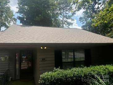 Charming single story home with tan siding, dark shutters, and mature landscaping at 102 Cedar Hollow St, Fort Mill, SC 29715